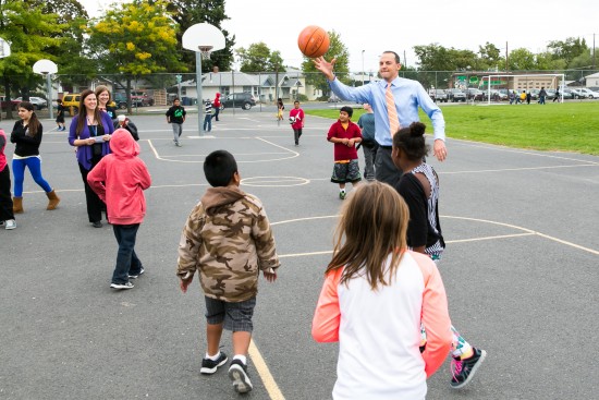Rep. Riccelli on playground at Stevens Elementary playing basketball with children