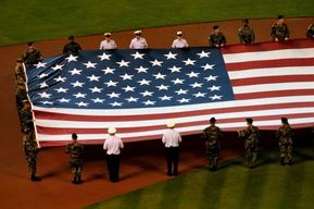 big american flag, baseball game, soldiers