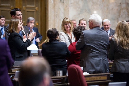 Rep. Patty Kuderer (D-Clyde Hill) is congratulated by her colleagues after the passage of her first bill on the House floor.