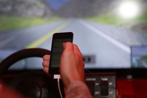 Photo of hand holding cell phone while driving