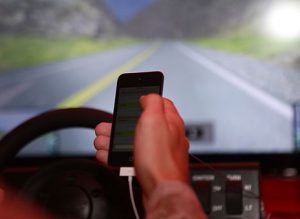 Photo of hand holding cell phone while driving