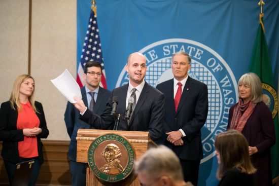 Rep. Drew Hansen holds a copy of his net neutrality bill, HB 2282, during a press conference in the Governor's Office