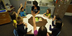 teacher and kids around classroom table