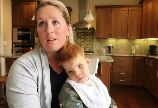 Lindsey Topping-Schuetz holds her nearly three-year-old son Owen who qualifies for developmental disabilities services, but has been denied them because of a lack of state funding.
