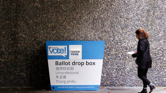 Woman takes ballot to drop box