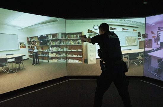  In a simulated hostage situation, Camas police Officer Kevin Hermann points his gun in a training apparatus at the Criminal Justice Training Center in Burien.