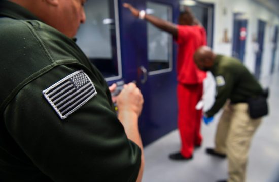A prisoner is searched at an ICE detention center