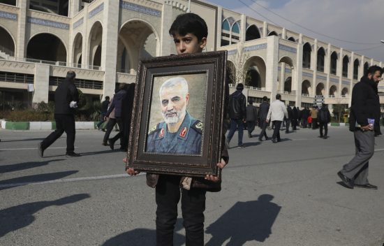 An Iranian boy holds a picture of Iranian Revolutionary Guard Gen. Qassem Soleimani