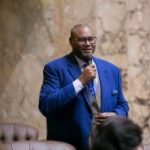 Rep Pettigrew speaking on the House floor in a blue suit