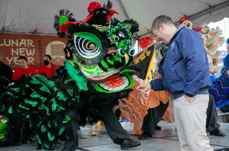 Edmonds Mayor Mike Nelson rewards a lion dancer with a traditional red envelope during a celebration of the Lunar New Year on Jan. 21, in downtown Edmonds. It may become the newest state holiday.