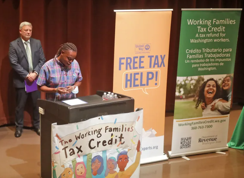 Olympic College student Nijhia Jackson describes how the Working Families Tax Credit will provide extra assistance for her family during a news conference Wednesday at the Central Library downtown. At left is John Ryser, acting director of the state’s Department of Revenue.