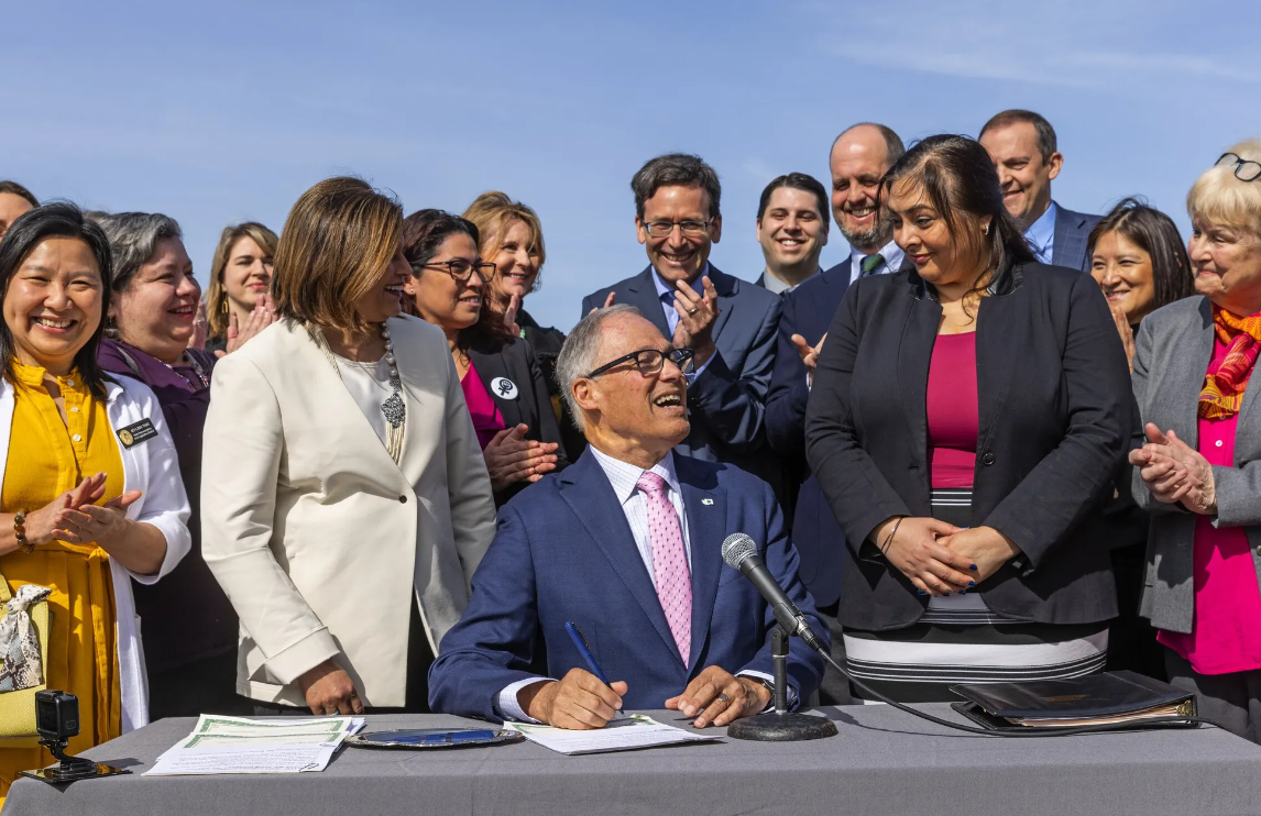 Washington Gov. Jay Inslee signs a slate of access to abortion bills Thursday on the University of Washington campus in Seattle.