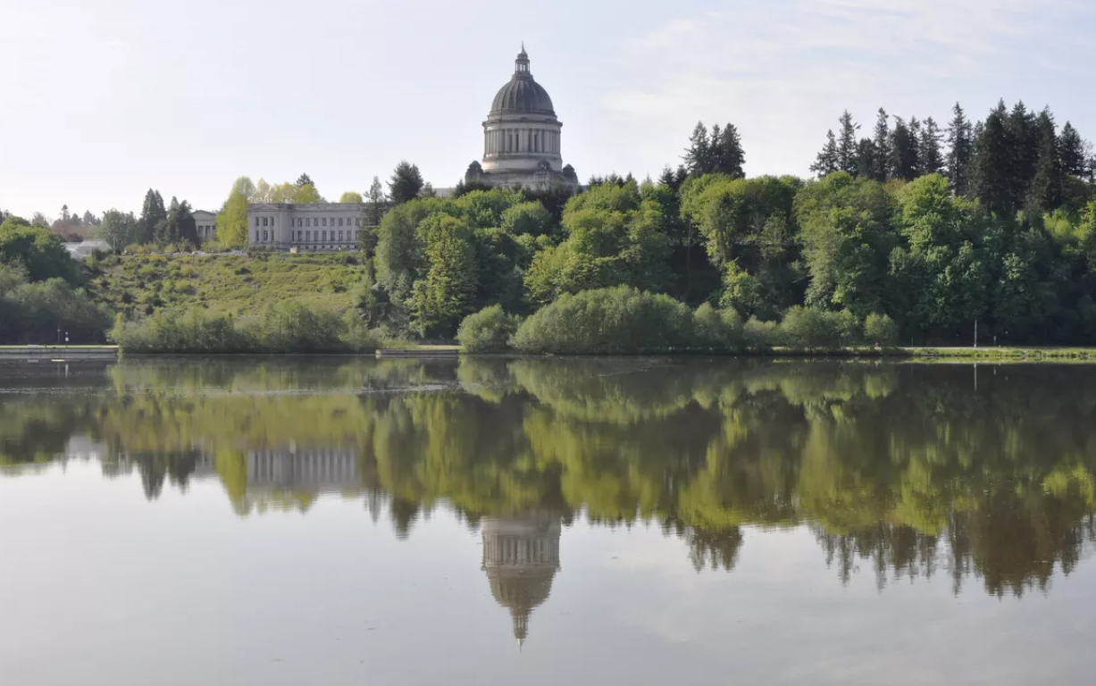 Washington’s domed Legislative Building, finished in 1928, and the nearby Temple of Justice reflected in the Capitol Lake on a calm day