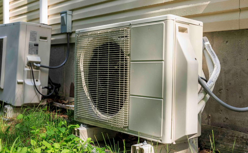 Washington state regulators want builders to install electric heat pumps, like the one pictured above, in new homes. A state panel is wrangling over rules to make it happen faster.