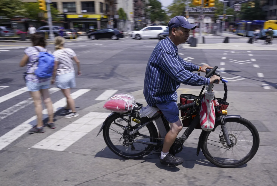 A man rides a motorized bicycle in New York. In Seattle, e-bike sharing programs are popular, and the state plans to launch purchase rebates available to individuals.