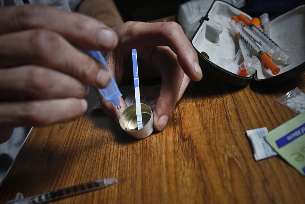  A drug user prepares heroin, placing a fentanyl test strip into a solution to check for contamination, in August 2018 in New York. Strips that test for the presence of fentanyl and xylazine are now legal in Washington state.