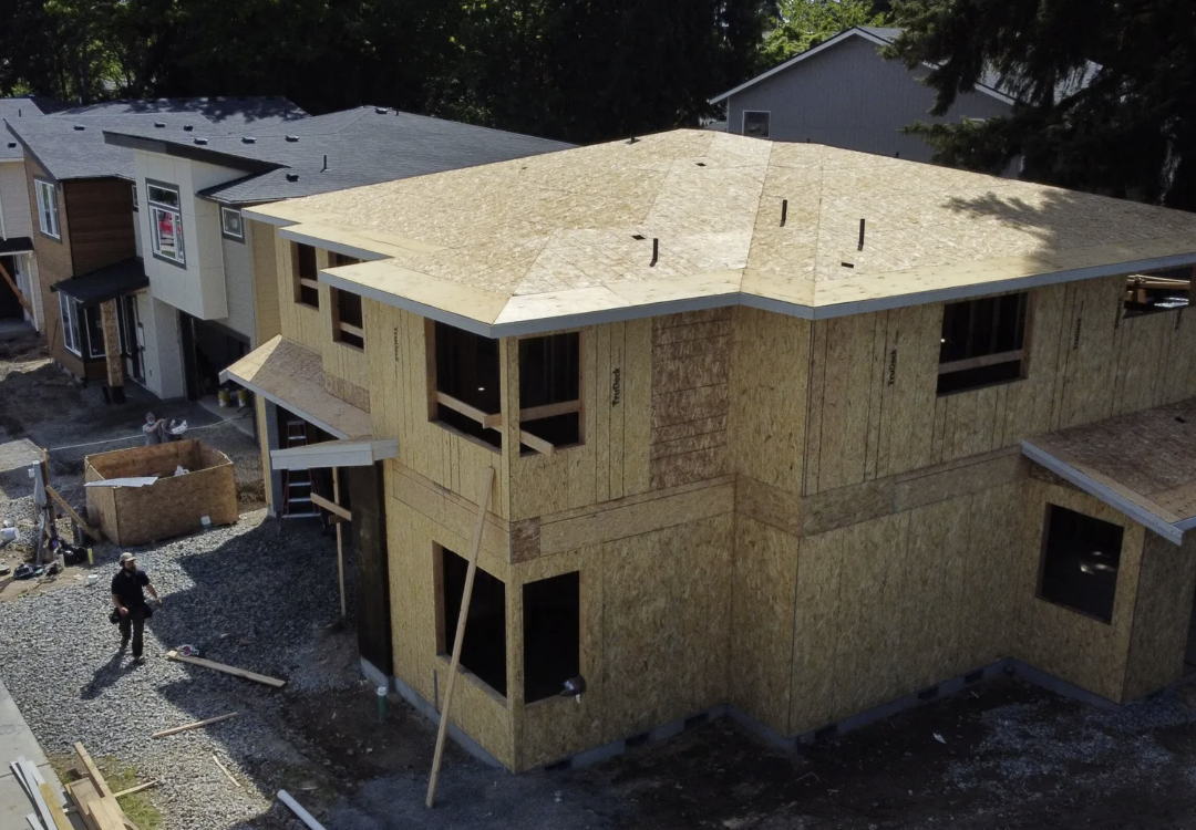 Houses in different stages of construction are seen in an aerial view in Kirkland. A new law in Washington will add important reporting requirements and accountability measures related to permit processing and review timelines in cities and counties, writes the author.
