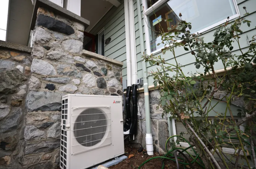 A heat pump outside a West Seattle house in February. Electric heat pumps effectively harvest warmth from outside air and transfer it indoors or, during the summer months, operate in reverse to keep temperatures low.