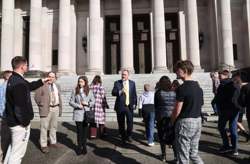 Wahkiakum School District Superintendent Brent Freeman, center, speaks with students and staff outside the Temple of Justice in Olympia in March after a hearing on the district’s suit over school building costs