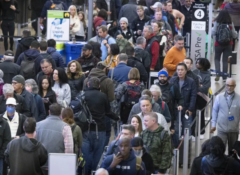 Travelers wait in a security line at Seattle-Tacoma International Airport, Nov. 17, 2023.