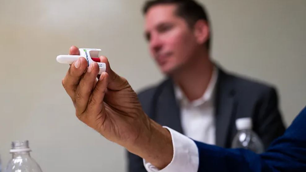  Gov. Jay Inslee holds a nasal dispenser of naloxone during a visit to the Washington Poison Center in October.