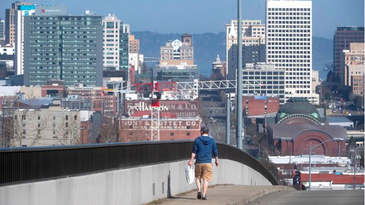 A man walks in the sunshine over downtown Tacoma, Washington, on Wednesday, March 22, 2023.