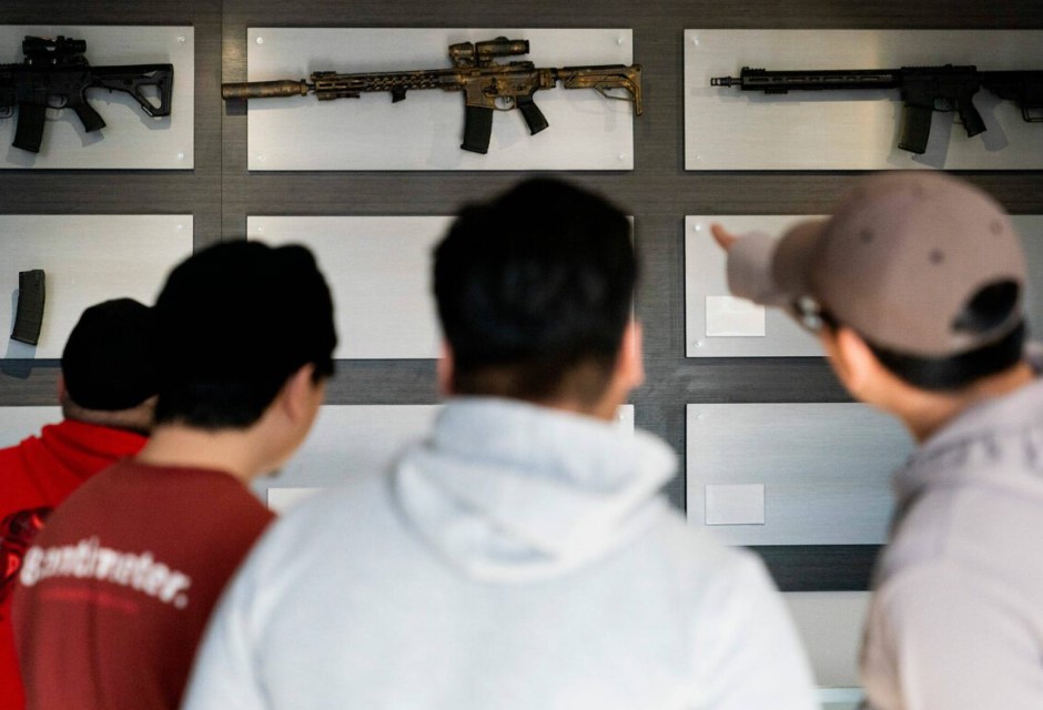 Customers look at AR-15-style rifles on a mostly empty display wall at Rainier Arms Friday, April 14, 2023, in Auburn, Washington, as stock dwindles before legislation bans future sale of the weapons in the state.