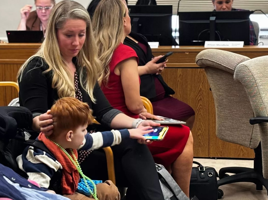 Lindsey Topping-Schuetz and her 7-year-old son, Owen, sit while members of the Senate Human Services Committee listen to public testimony to allow parental caregivers of children with disabilities to receive payment on Jan. 30, 2024, in Olympia.