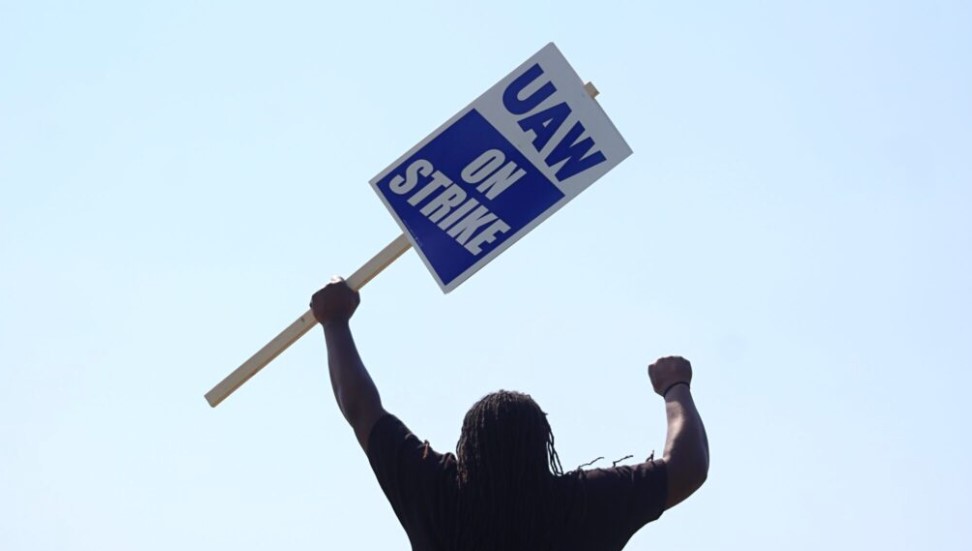 A UAW worker holds a strike sign