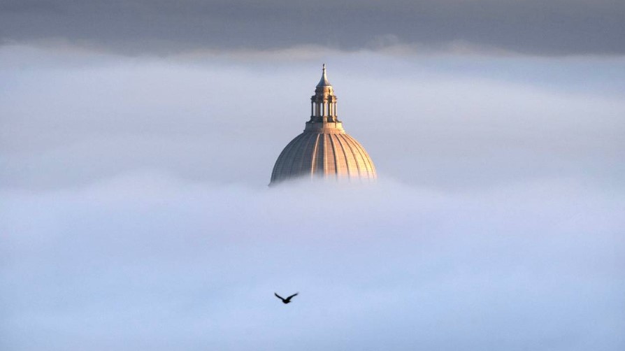 The Washington State Capitol pops out of the thick fog on a freezing morning as seen from Overlook Park in Tumwater, Washington, on Friday, Nov. 24, 2023. 