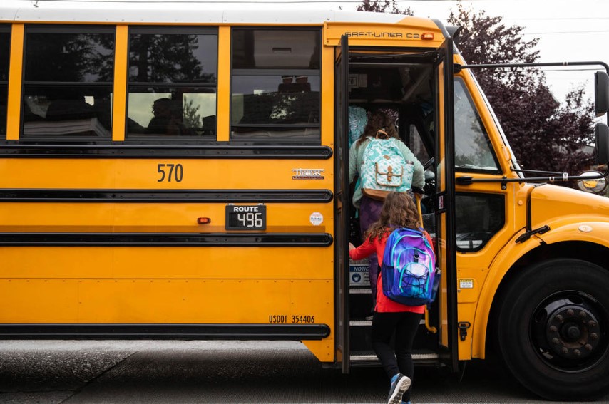 Students board the bus to Hamilton International Middle School on the first day of school in this Sept. 14, 2022 file photo. A proposal to transition Washington’s diesel-powered school buses to zero-emission alternatives has passed the Legislature.