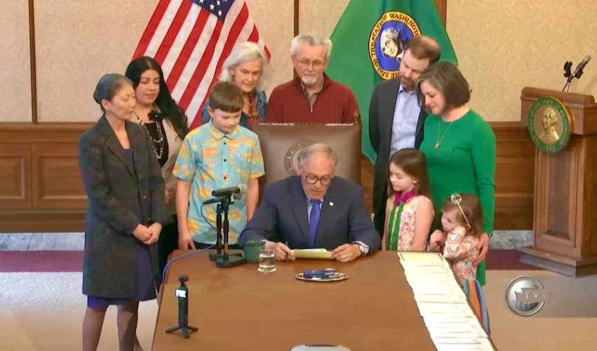 Washington Gov. Inslee signs HB 1239 into law with the Rigg Hillard family and Rep. Santos on March 25, 2024.