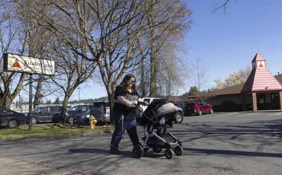 Nicole Slemp of Auburn walks past a KinderCare while out with infant son William. While looking for child care after William’s birth, Slemp and her husband found that even the most inexpensive option would... (Ellen M. Banner / The Seattle Times)