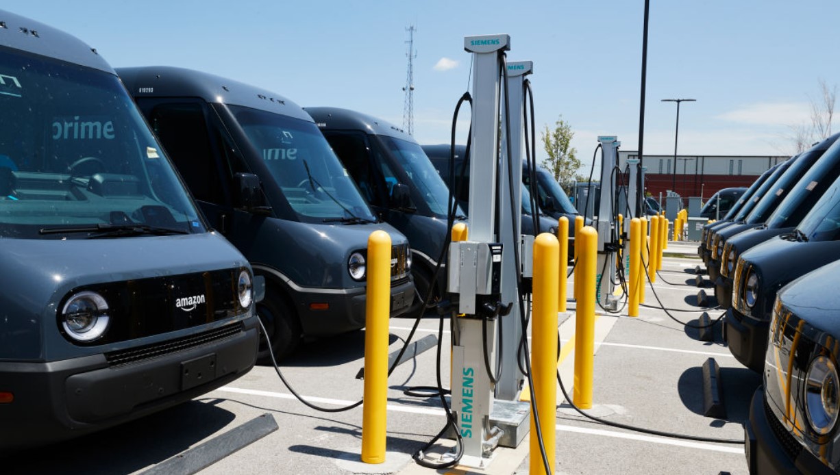 A fleet of electric delivery vehicles charges. A new network of stations up and down the West Coast could accelerate the adoption of more electric vehicles across the region. (Mustafa Hussain/Getty Images)