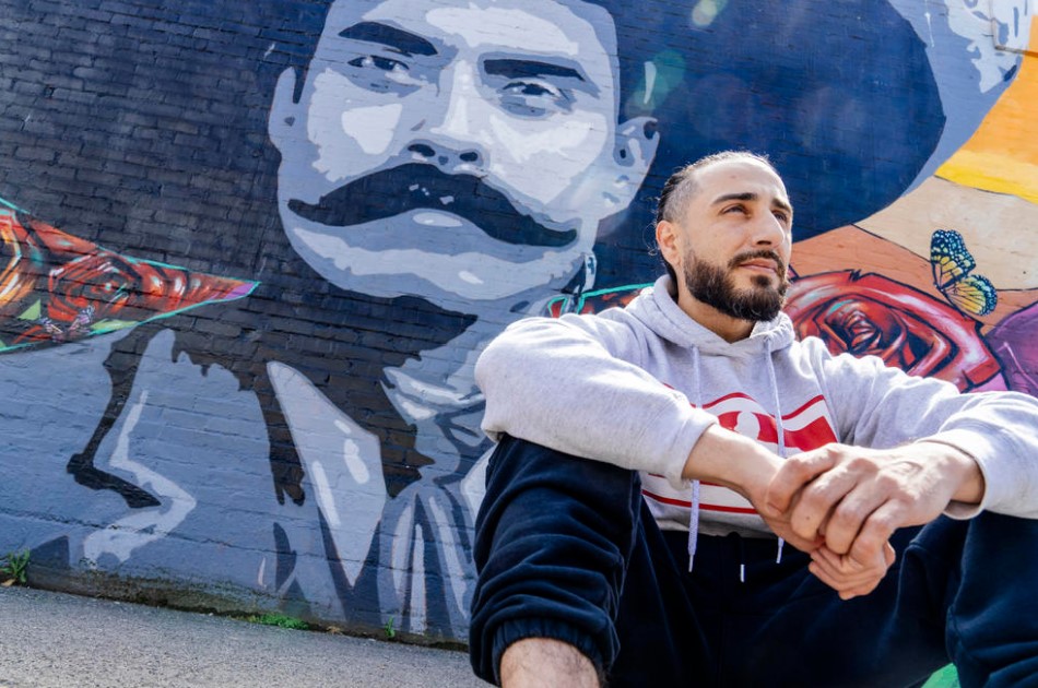 Mural artist Crick Lont (known as dozer_art on social media) is seen next to a commissioned mural he painted, with local graffiti writer Charms, on the exterior of La Esperanza Mercado Y Carniceria in Beacon Hill, Thursday, May 30, 2024. The mural features a large portrait of Mexican revolutionary Emiliano Zapata alongside the landscape, flora, and fauna, of the Sonoran Desert. The pair painted the mural in 2020 and, Lont says, wanted it to 