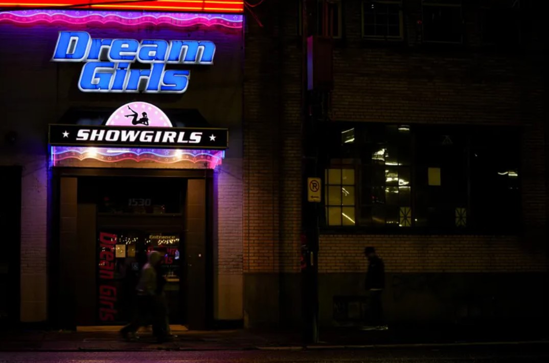 People walk by the Dream Girls, a strip club in Seattle’s Sodo neighborhood. It is the first strip club in Washington to get a liquor license in nearly 50 years thanks to a law passed this year. (Lindsey Wasson / The Associated Press)