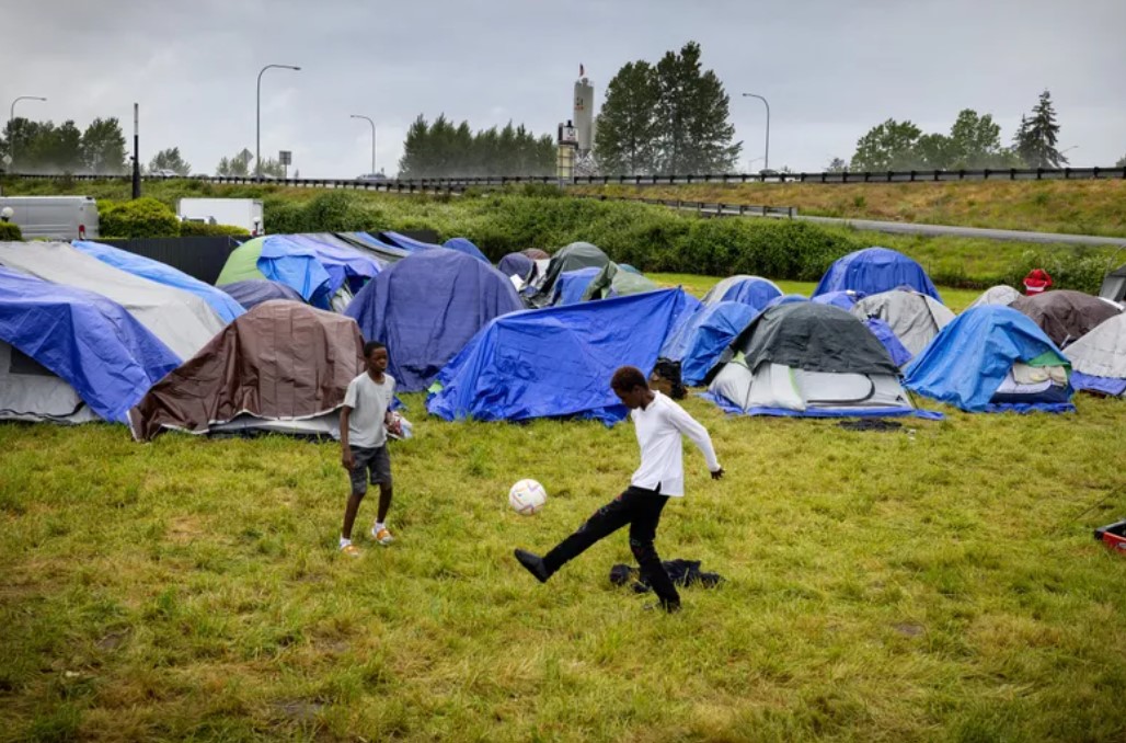 Two boys from Angola play soccer. They are some of about 200 asylum-seekers who lived at an encampment in Kent during June and early July. (Ken Lambert / The Seattle Times)