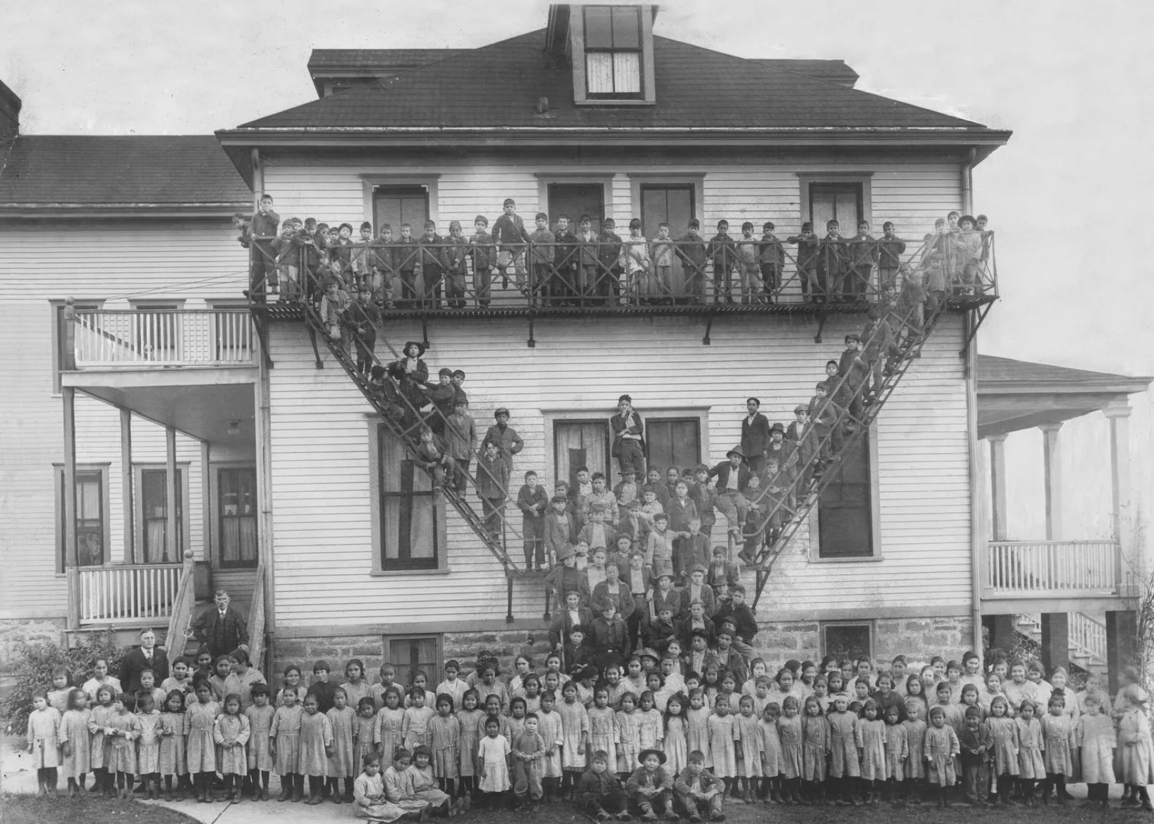 A 1923 photo taken by Darius Kinsey near Tulalip Bay includes students standing outside of one of the Tulalip Indian School dormitories. The school closed in 1932 and was one of an estimated 417 Native American boarding schools... (Hibulb Cultural Center)