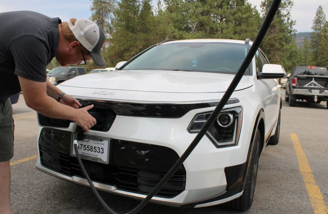 Brandon Hansen, resident of Chewelah, plugs in his Kia Niro to charge at the Chewelah Golf and Country Club. Hansen switched to an electric vehicle earlier this year after being impressed on a test-drive. (Monica Carrillo-Casas/The Spokesman-Review)