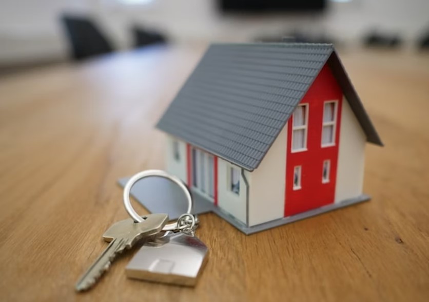 Toy house on a table with keys next to it