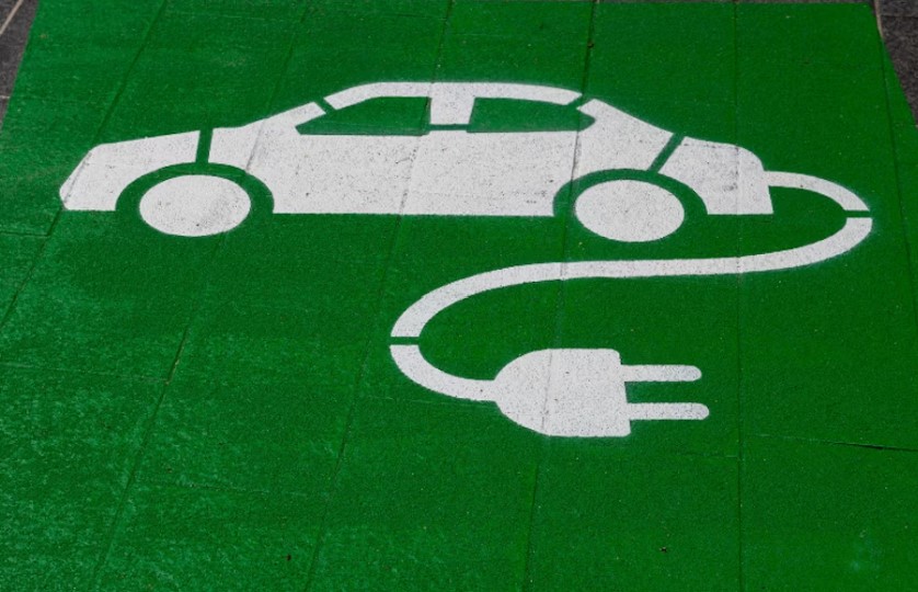 A photo of a white electric car stamped onto a green square