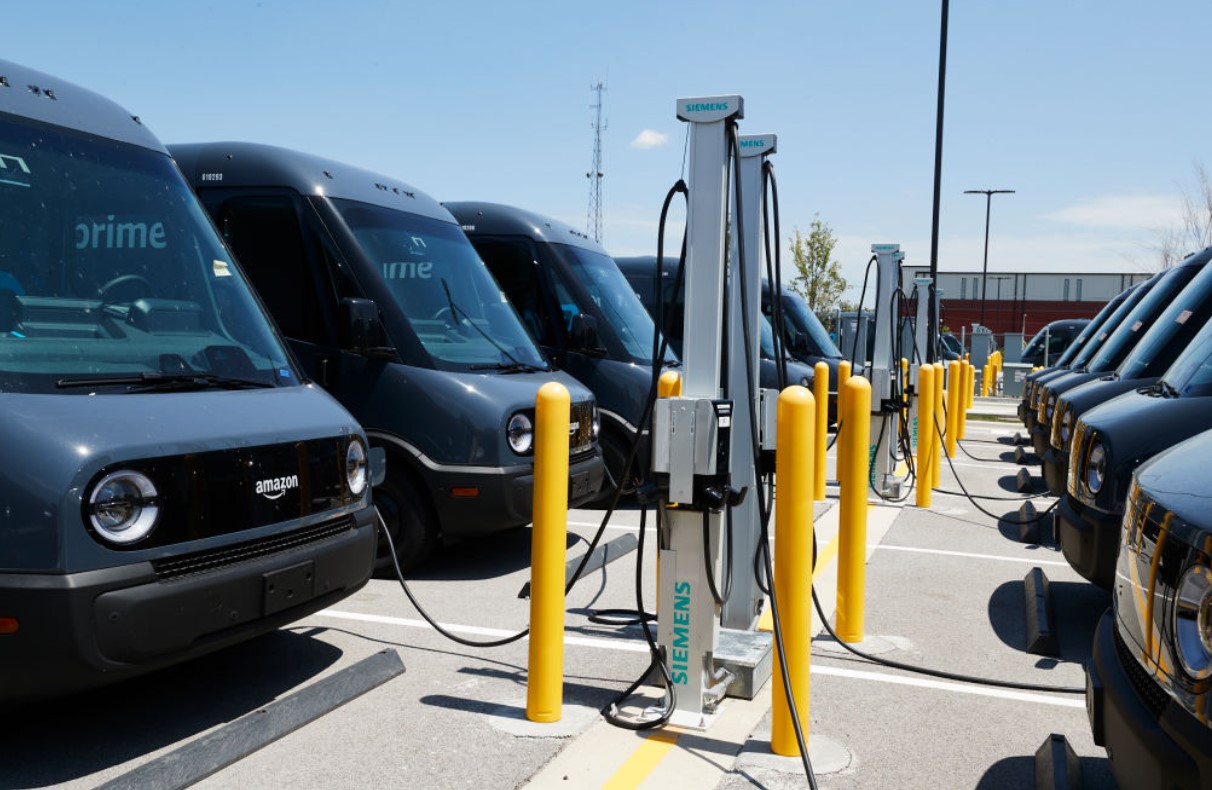 A fleet of electric delivery vehicles charges. A new network of stations up and down the West Coast could accelerate the adoption of more electric vehicles across the region. (Mustafa Hussain/Getty Images)