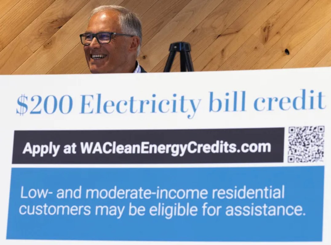 Gov. Jay Inslee announces a new program that will credit eligible households with $200 on their electricity bill, thanks to funding from the state Climate Commitment Act, at a news conference in Seattle on July 29. (Ken Lambert / The Seattle Times)