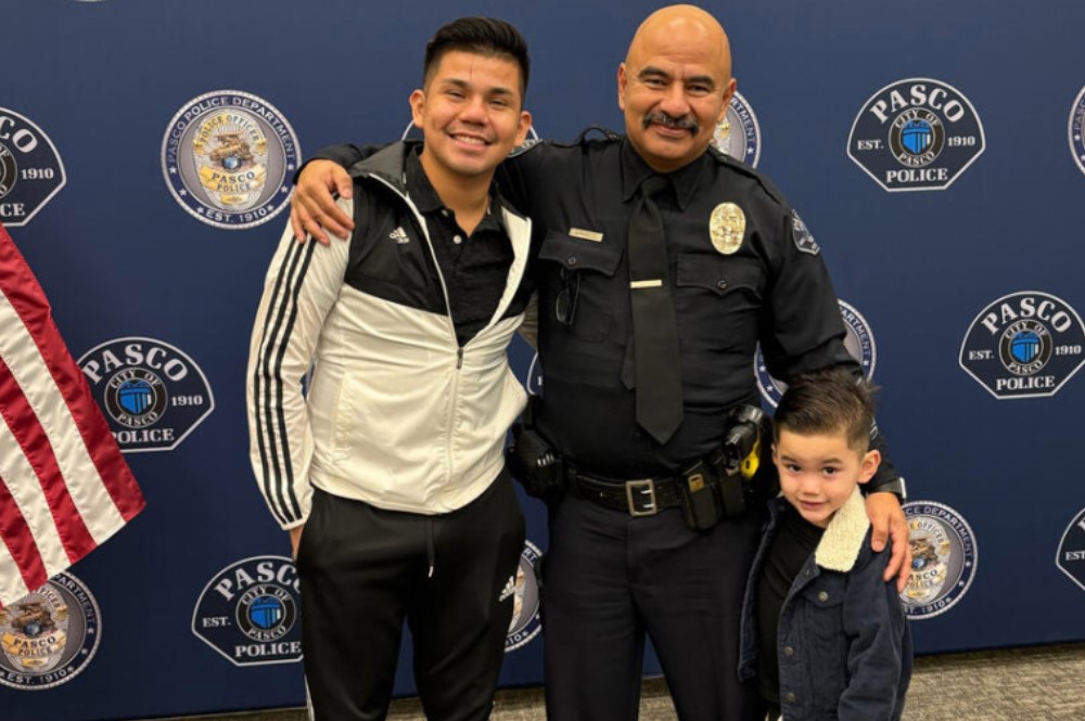 Victor Manuel Arzate poses with his son and retired officer Raymond Aparicio, who mentored Arzate growing up. (Mary Murphy for Cascade PBS)