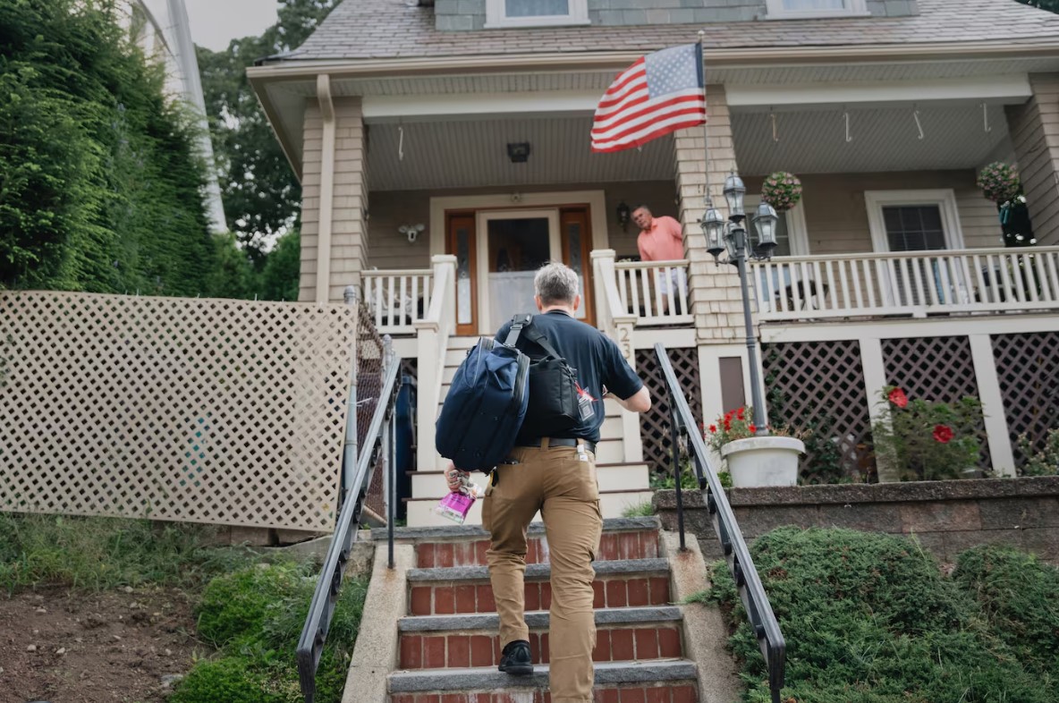 Berry is greeted by his patient’s husband, Kevin Castater, as he arrives at their house for a daily check in. It is the first of several home visits the paramedic makes that day. (Kieran Kesner/For The Washington Post)