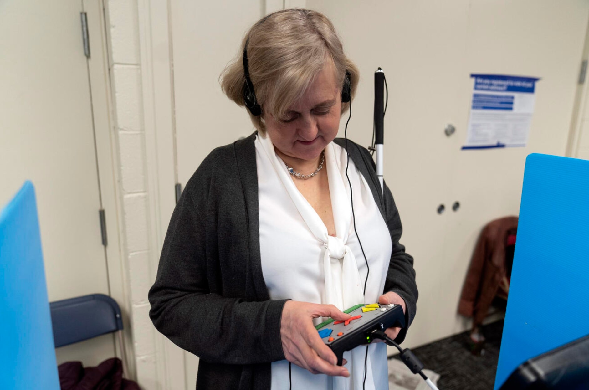 Patti Chang, who is blind, uses headphones and audio along with an electronic controller outfitted with braille to vote in the Chicago mayoral runoff election at the Roden Branch of the Chicago Public Library on Wednesday, March 22, 2023. Washington voters who are visually impaired use a similar system for in-person voting. (AP photo Erin Hooley)