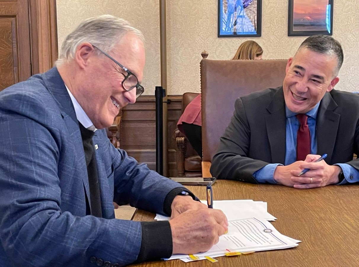  Gov. Jay Inslee and Secretary of State Steve Hobbs sign documents on Dec. 4, 2024 certifying results in the 2024 Washington state general election. (Jerry Cornfield/Washington State Standard)