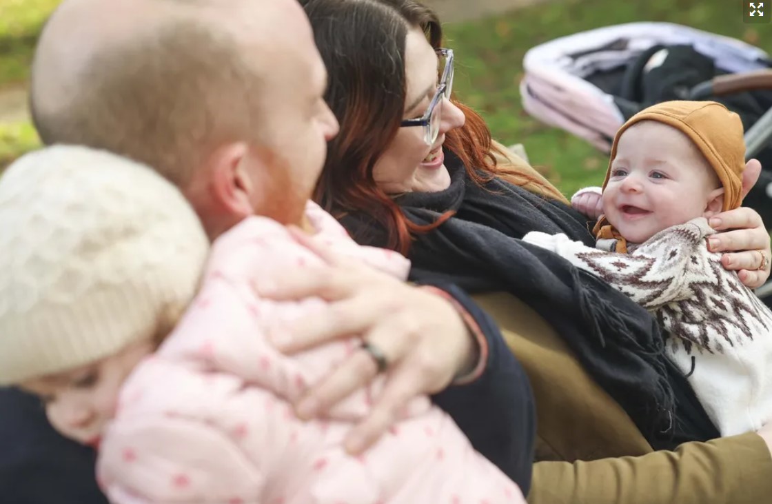 From left, Anastasia Sioleski, 2, Jon Sioleski, Alison Fasolino and Luka Sioleski, 3 months, share a moment at Bhy Kracke Park in Seattle last week. (Ivy Ceballo / The Seattle Times)