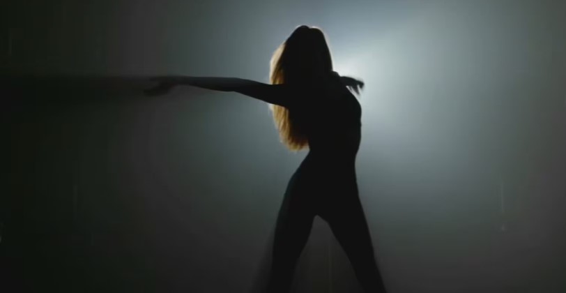 Silhouette of a person with long hair, standing with outstretched arms