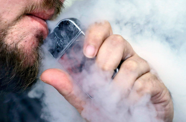 A man using an electronic cigarette exhales in Mayfield Heights, Ohio, in October 2019. (Tony Dejak / Associated Press file)